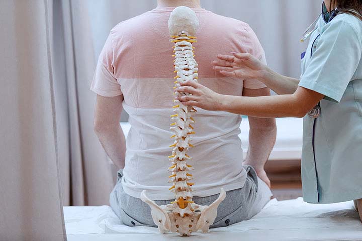 What is Regenerative Medicine? Unveiling Future Healing; Caucasian nurse holding spine model against the patients backs. Clinic interior.
